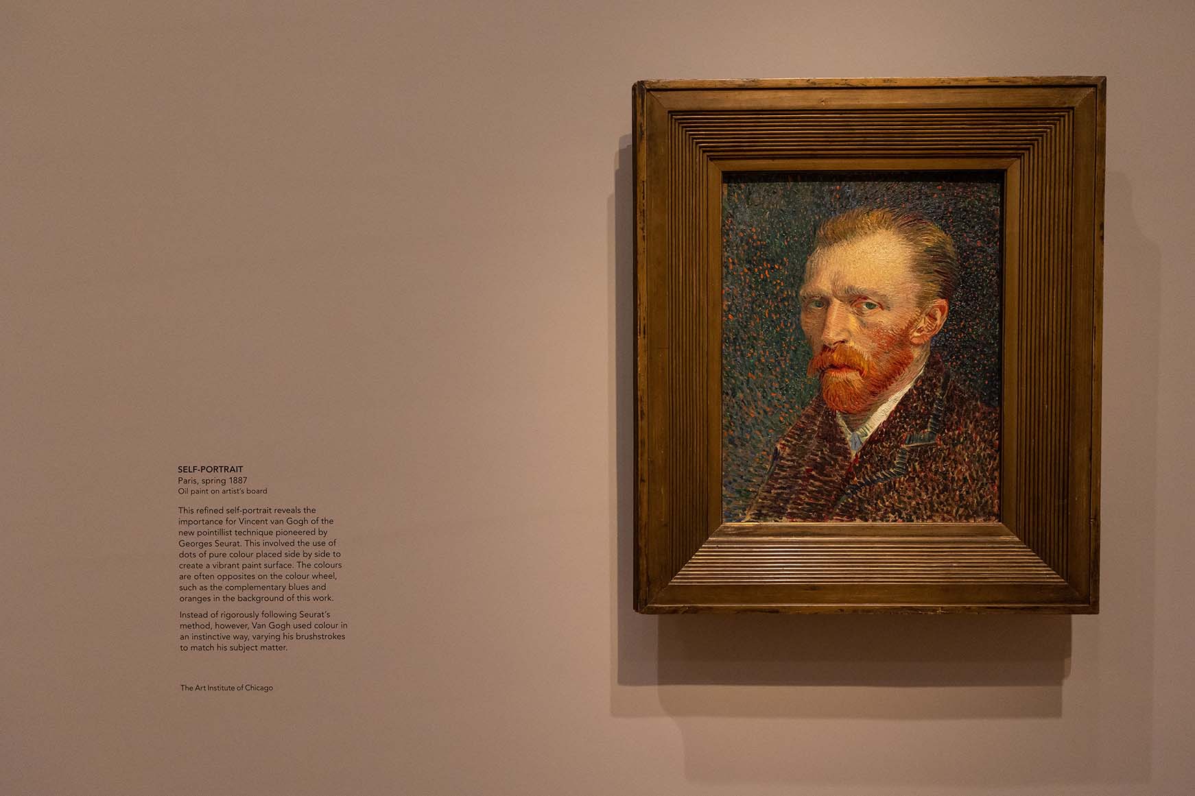 Self-portrait of Vincent van Gogh wearing coat on gallery wall